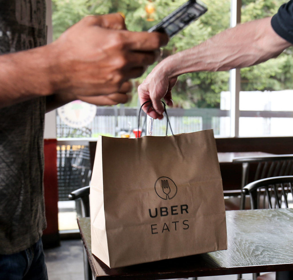 A driver picks up an order from Red Onion Burgers in Mountlake Terrace. (Kevin Clark / The Herald)
