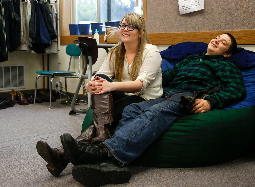McKayla Olson, 18, and her longtime boyfriend, Andrew Anthony, 20, enjoy watching the prom dress fashion show as classmates come by to try on formal wear Thursday. (Dan Bates / The Herald)
