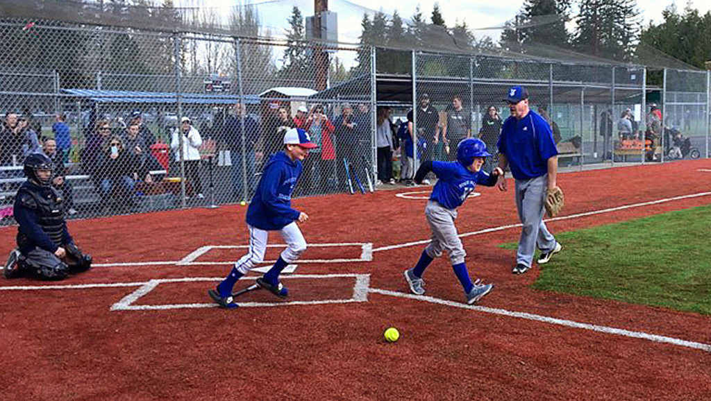 Jacob takes off up the first base line with his brother, Noah, following close behind after making a hit while playing some ball with the Stilly Softball girls team. (Courtesy Stilly Valley Little League)
