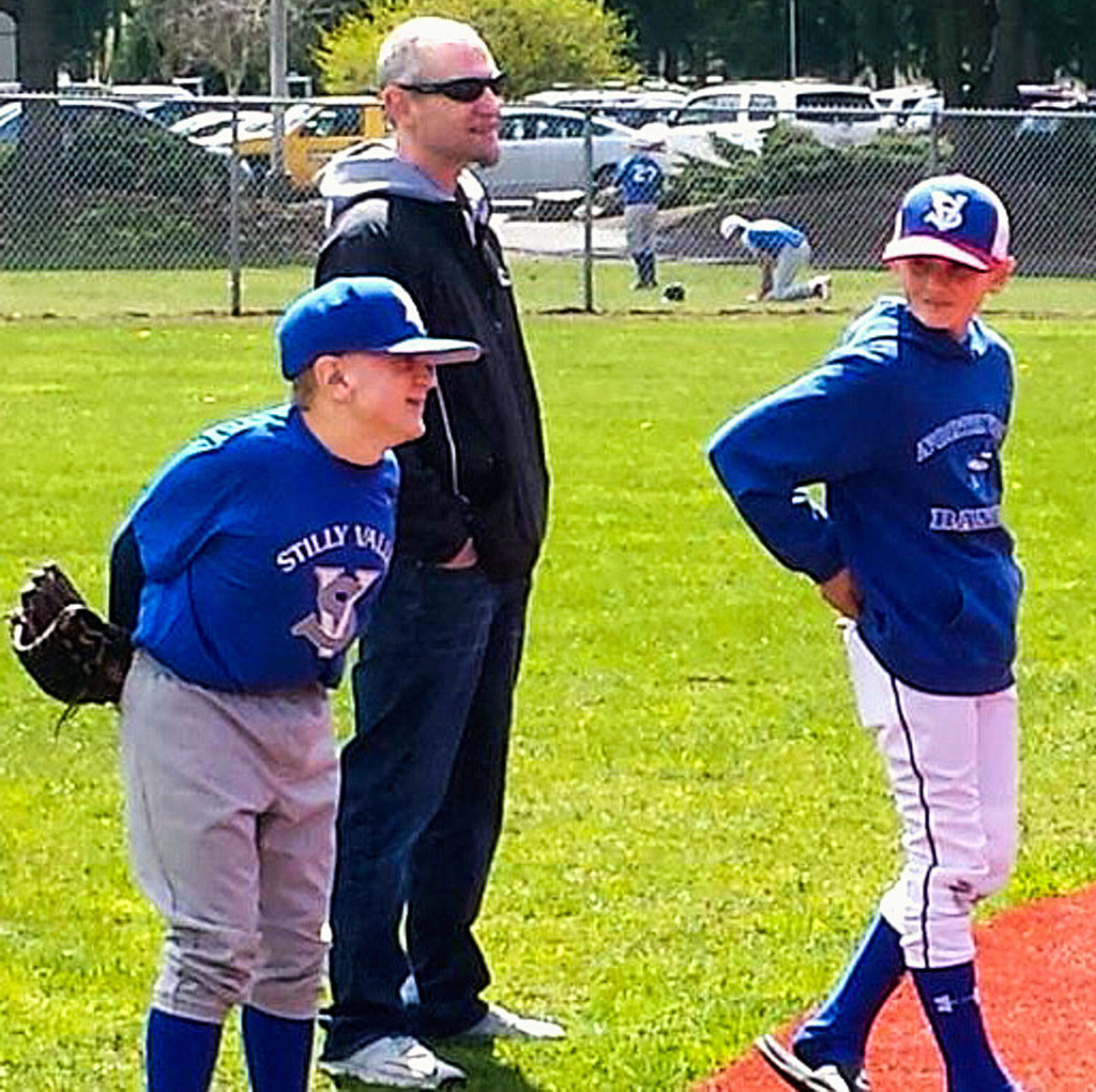 Jacob is all smiles as he plays second base. He is helped by his father, Steve Irish, and brother Noah. (Melanie Irish photo)
