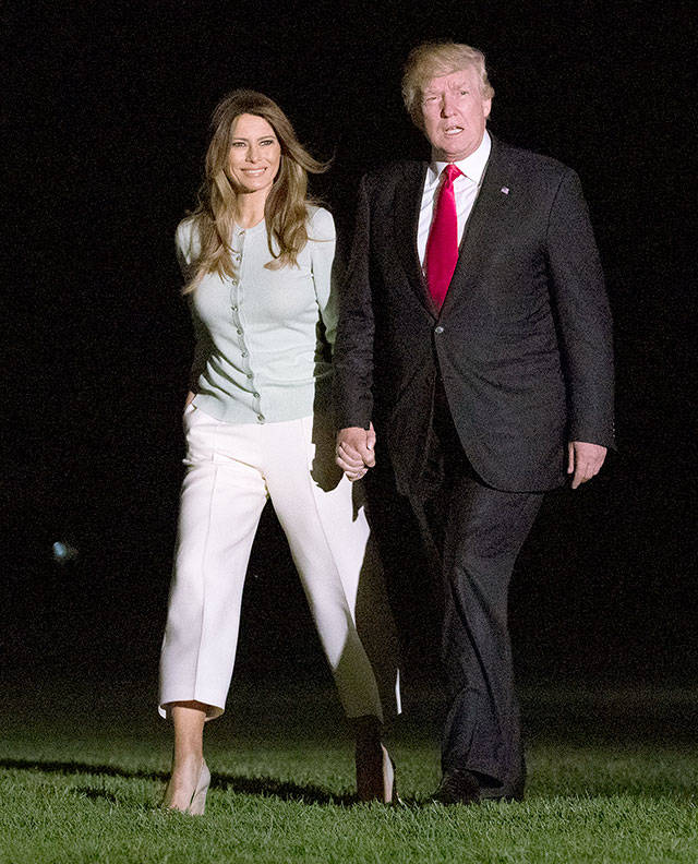 President Donald Trump and first lady Melania Trump walk from Marine One across the South Lawn to the White House in Washington on Saturday as they return from Sigonella, Italy. (AP Photo/Carolyn Kaster)