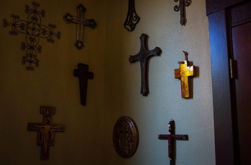 The Yeadons’ collection of crosses hang in the entryway to their church house in Mukilteo. The crosses are from as far away as Spain and as nearby as Target, they said. (Daniella Beccaria / For The Herald)
