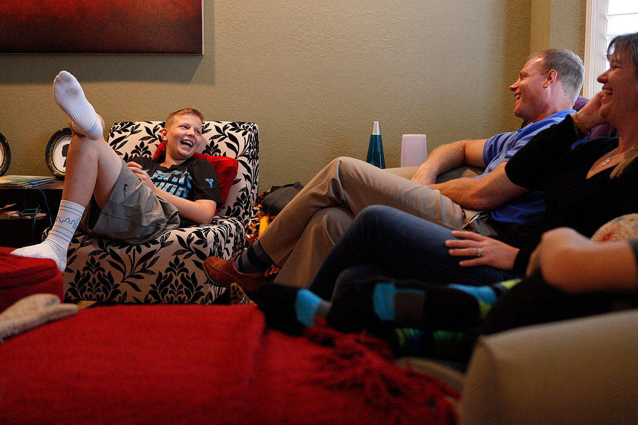 Colton Matter, then 14, laughs with his parents Jeff and Suzy Matter at the family’s home in Mill Creek in September, 2014. Colton, now 16, and a varsity golfer for Jackson High School, has fought leukemia since he was 9, and is now in remission. His mother recently said she is concerned what might happen if the Affordable Care Act is repealed. (Ian Terry / Herald file photo)