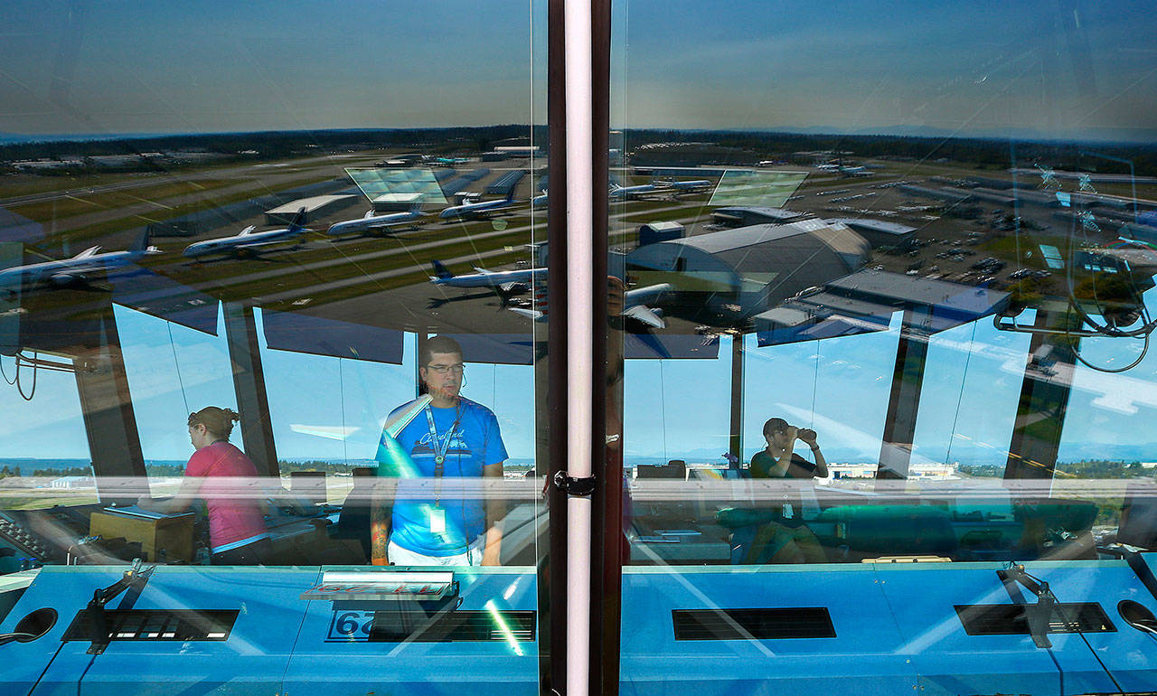 Air traffic controllers Bridget Monroe (left), John Holcepl (center) and Chris Taylor watch the skies from the FAA control tower at Paine Field in September, 2014. (Mark Mulligan / Herald file photo)