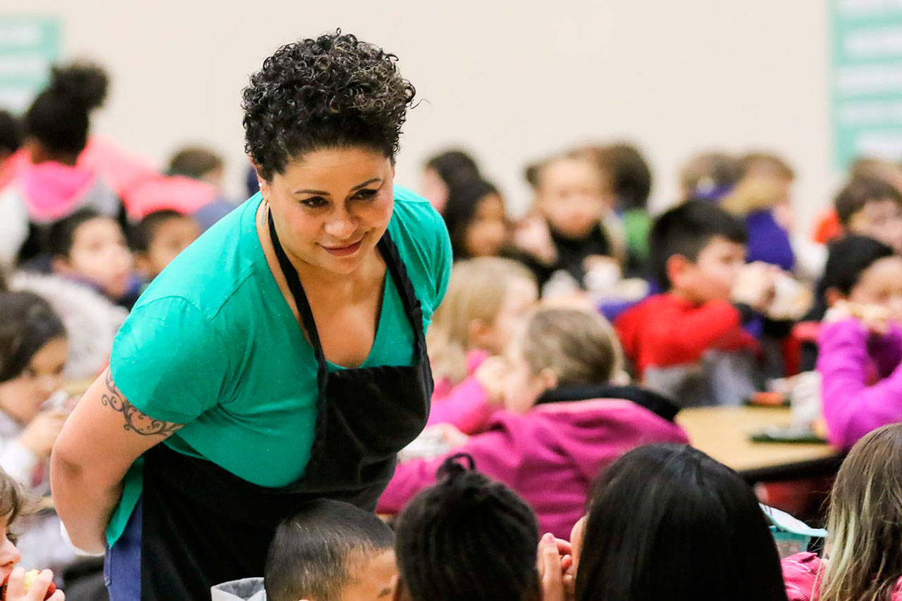 Lisa Gaines, the Nutrition Services lead at Challenger Elementary School in Everett, walks the aisles and talks to students during lunch earlier this year in February. (Kevin Clark / Herald file photo)