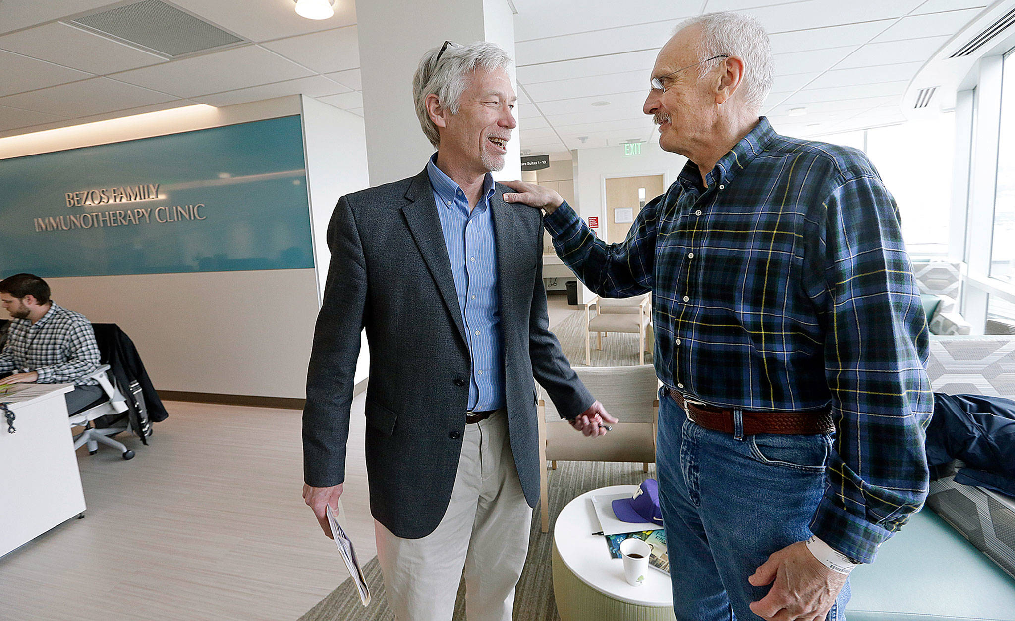 Dr. David Maloney of the Fred Hutchinson Cancer Research Center in Seattle is greeted by patient Ken Shefveland, whose lymphoma was successfully treated with CAR-T cell therapy. Immune therapy is the hottest trend in cancer care and its next frontier is creating “living drugs” that grow inside the body into an army that seeks and destroys tumors. (AP Photo/Elaine Thompson)