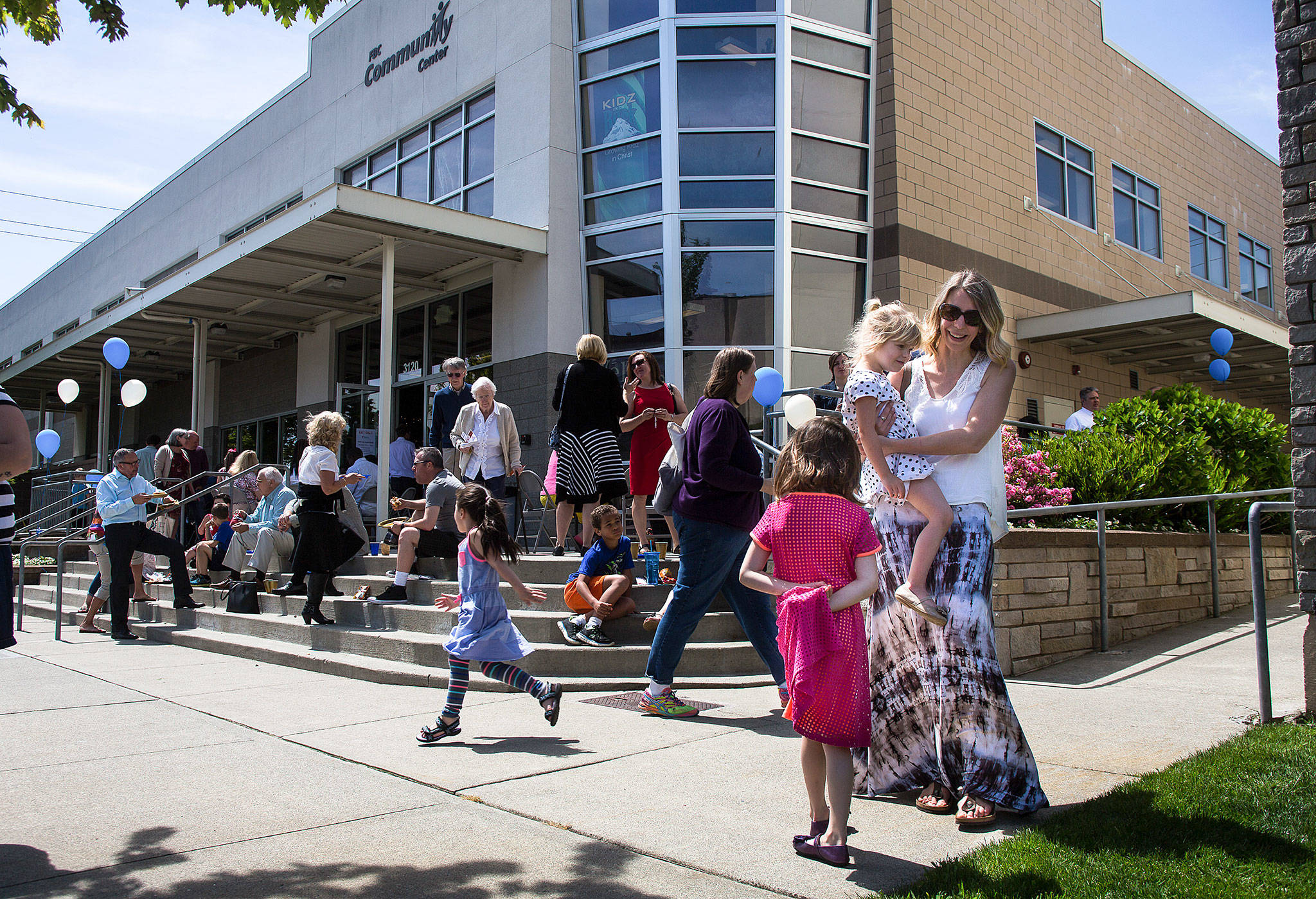 Emily Chilson and her daughters Noelle Chilson, 6, and Zoe Chilson 4, enjoy the sunshine during a celebration of 125 years since the founding of the Everett First Baptist Church on Sunday, May 21. Members enjoyed a BBQ and other festivities to commemorate the occasion. (Daniella Beccaria / For the Herald)