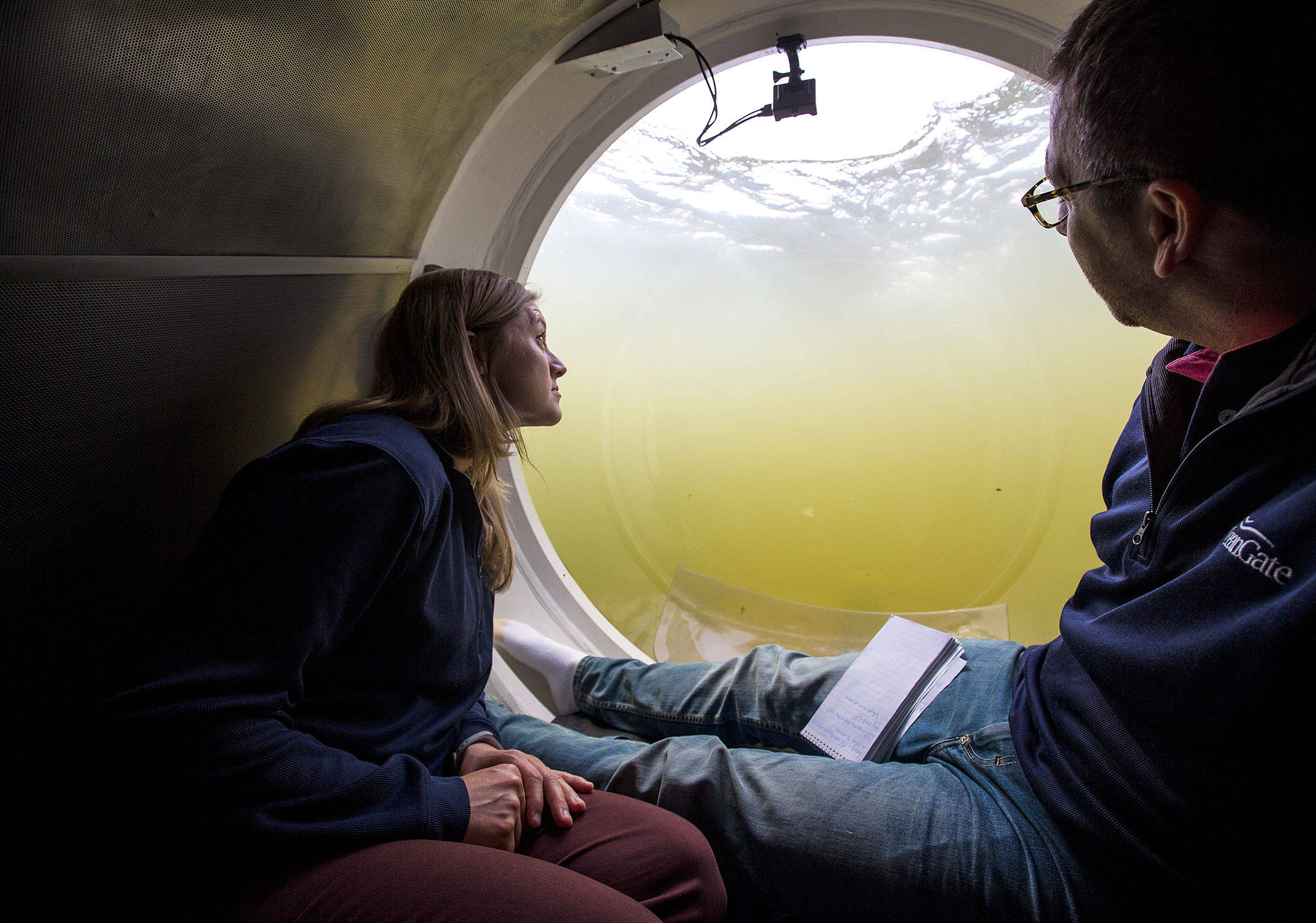 Bonnie Carl (left) and Josh Dean look out the dome as the OceanGate submarine Cyclops I submerges in the Port of Everett Marina recently. OceanGate plans to carry paying customers on dives to the RMS Titanic in 2018. (Andy Bronson / The Herald)