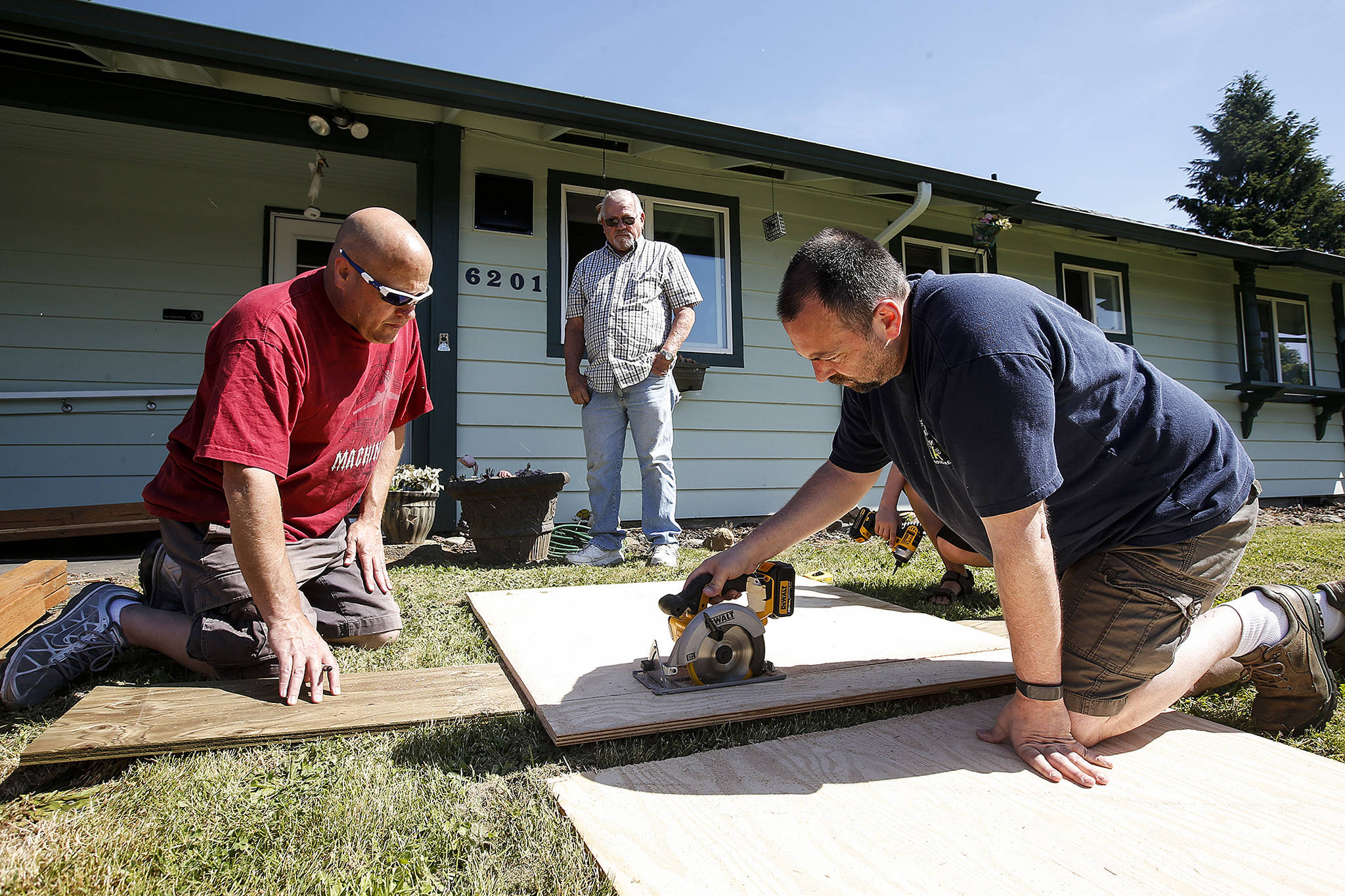 Machinist union members Steve Morrison (left), of Marysville, and Mike Hill, of Stanwood, work to install a wheelchair ramp at a home in Marysville on Saturday, May 27. (Ian Terry / The Herald)