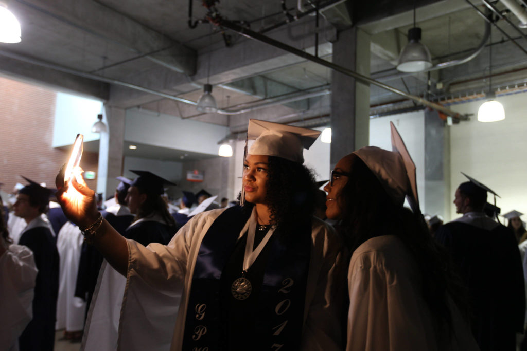 Glacier Peak High School seniors Kayla Watkins (left) and Areha Jackson take a selfie photo together before their graduation ceremony at Xfinity Arena on Monday in Everett. (Andy Bronson / The Herald) 

