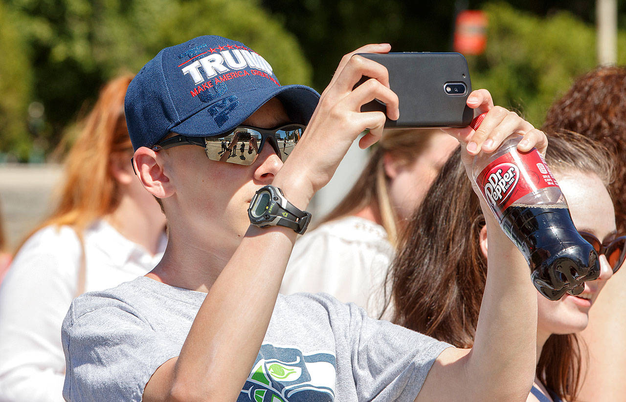 Bryce Howard, 15, of Everett, wears a Trump hat as he snaps a photo during a visit to the Supreme Court in Washington on Monday, where justices issued their final rulings for the term. The high court is letting a limited version of the Trump administration ban on travel from six mostly Muslim countries take effect. (AP Photo/J. Scott Applewhite)