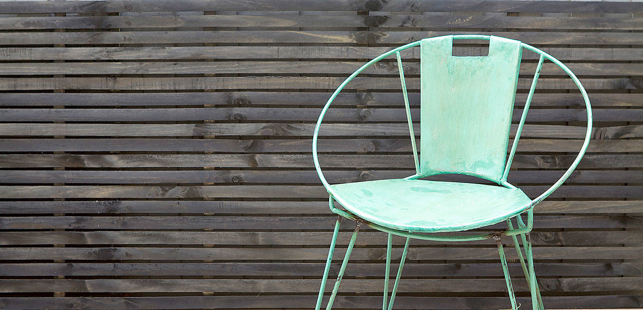 Very dark or black fences make a bold modern statement. Uninterrupted horizontal slats will create a contemporary space that feels connected to the earth and cozy. (Dreamstime)