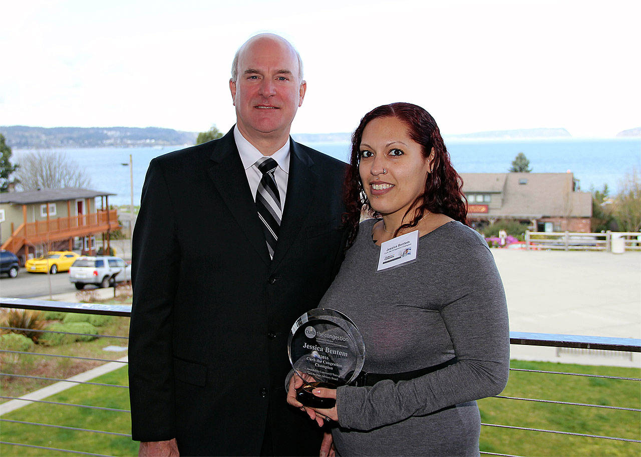 Community Transit CEO Emmett Heath presents the 2016 Curb the Congestion Champion of the Year award to Jessica Bentem of Everett. (Contributed photo)