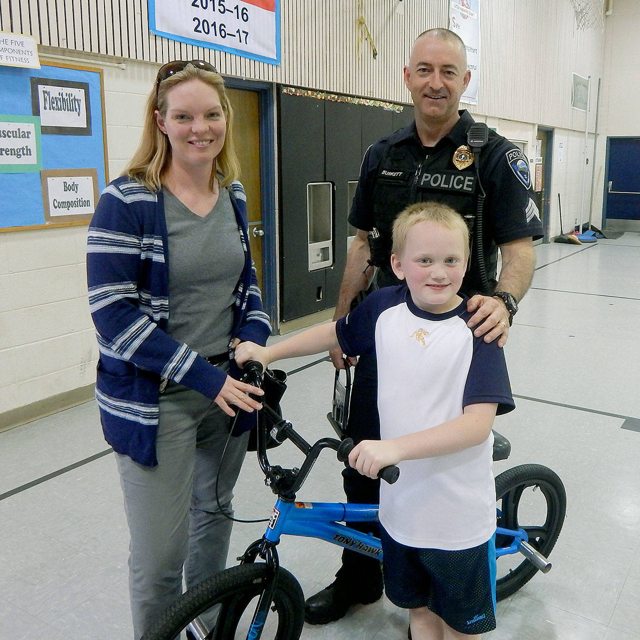 Mountlake Terrace police detective Heidi Froisland and Sgt. Scott Burkett meet with Jack Chalmers, 8. Police used a benevolent fund to replace Jack’s stolen bike. (Mountlake Terrace Police)