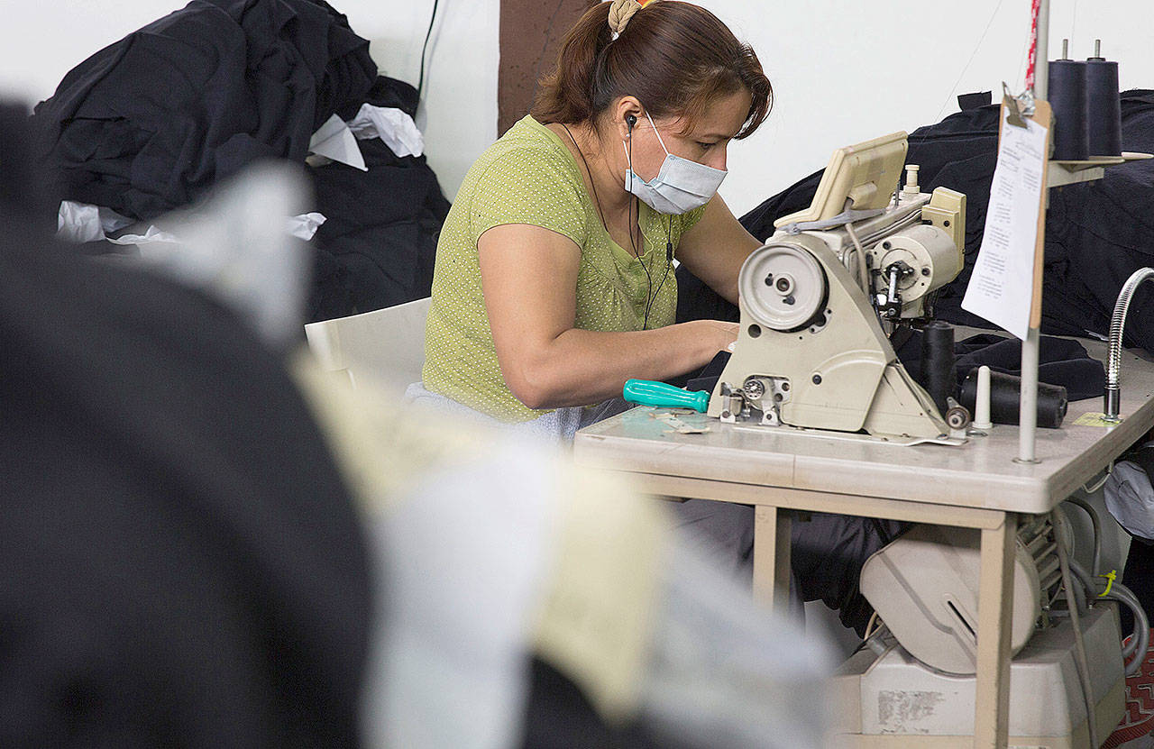 A worker sews fabric during the assembly process at the 5 Thread facility in Los Angeles in 2016. (Bloomberg / Meg Roussos)