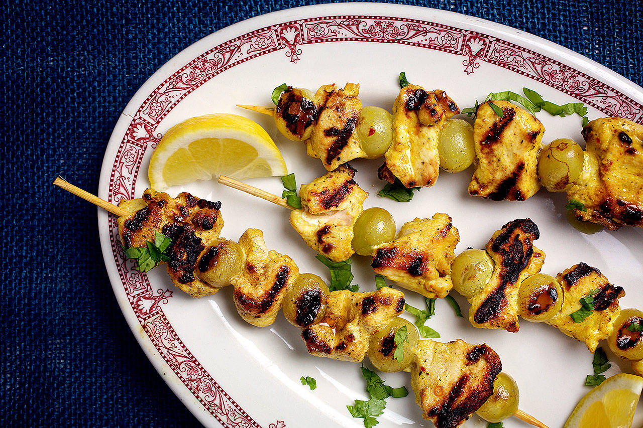 Grilled grapes provide a sweet counterpoint to the savory of spiced chicken skewers. (Photo by Deb Lindsey for The Washington Post)