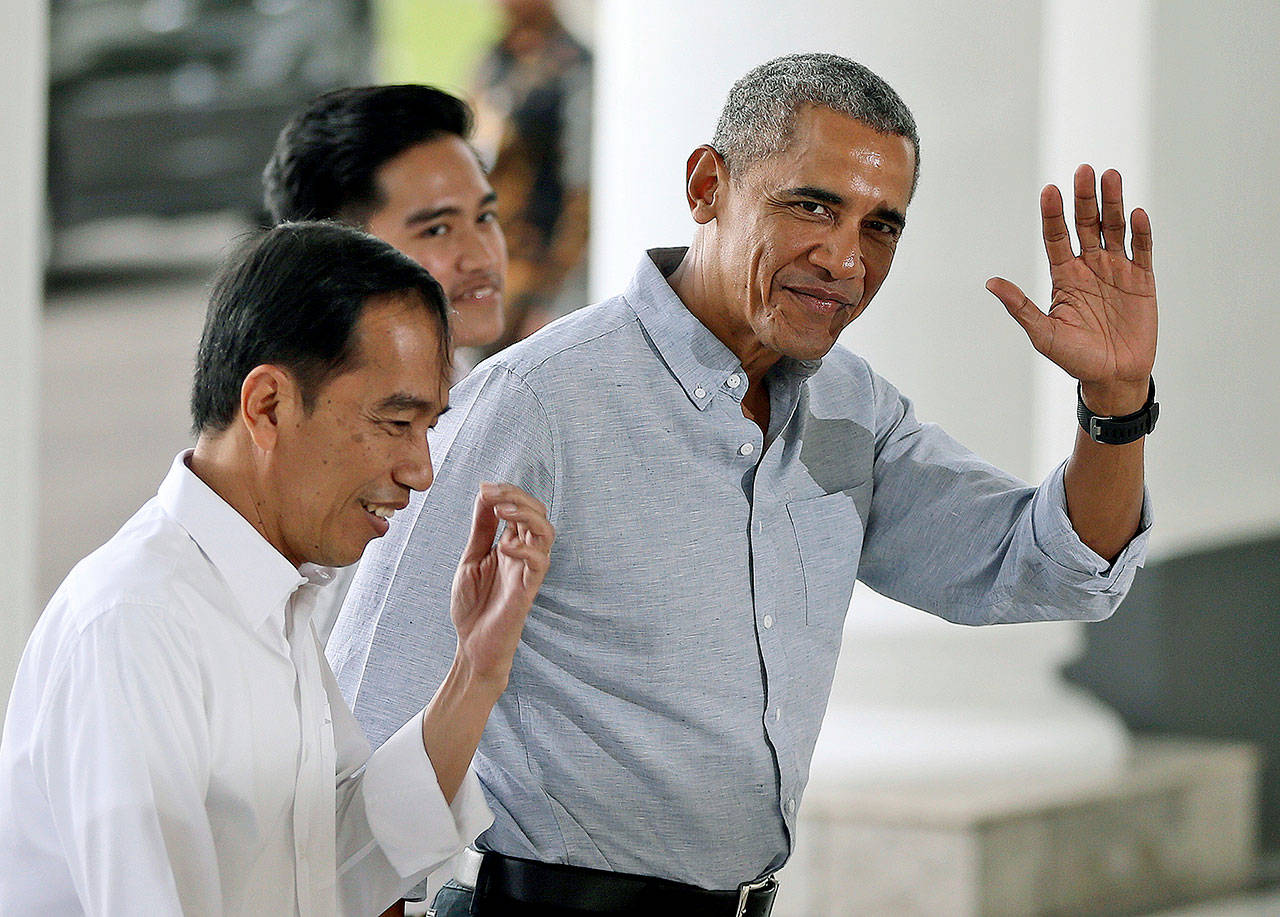 Former U.S. President Barack Obama waves to reporters as he walks with Indonesian President Joko Widodo (left) upon arrival for their meeting at the Bogor Presidential Palace in Bogor, West Java, Indonesia, on Friday. Obama and his family arrived Friday in his childhood home of Jakarta on the tail-end of their 10-day vacation to the country, where they were spotted whitewater rafting and visiting ancient temples. (AP Photo/Dita Alangkara, Pool)
