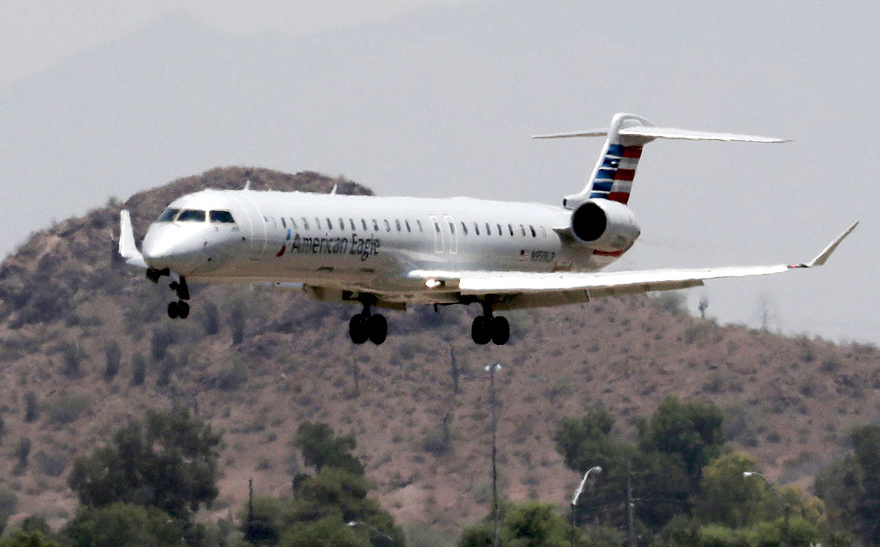 An American Eagle jet is seen through heat ripples as it lands at Sky Harbor International Airport on Monday, June 19, in Phoenix. American Airlines cancelled dozens flights out of Phoenix today due to extreme heat. (AP Photo/Matt York)