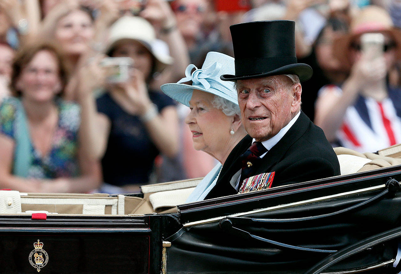 Queen Elizabeth II (left) and Prince Philip return to Buckingham Palace in a carriage on Saturday after attending the annual Trooping the Colour Ceremony in London. (AP Photo/Kirsty Wigglesworth, File)