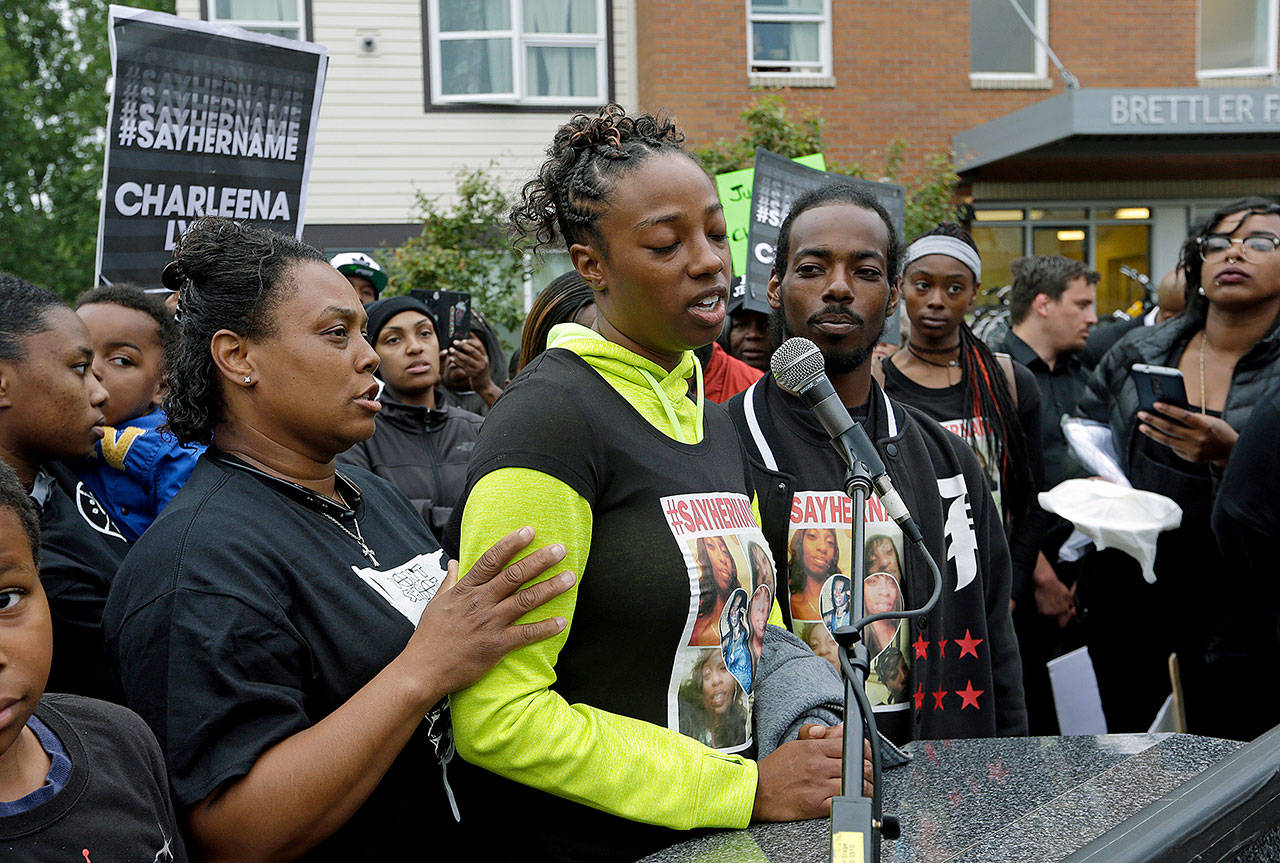 Monika Williams (center) stands with her brother, Domico Jones, as she talks on Tuesday about their sister, Charleena Lyles, at a vigil outside where Lyles was shot and killed Sunday by police in Seattle. (AP Photo/Elaine Thompson)