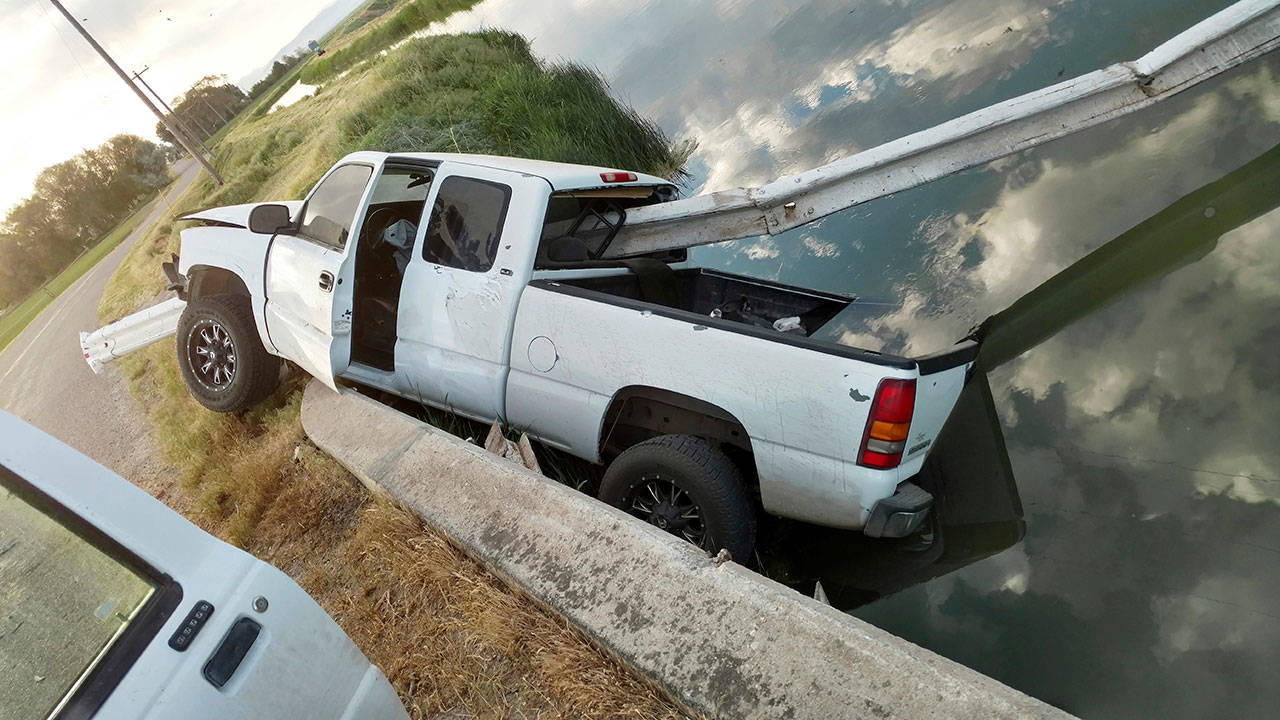 This stolen pickup truck was found impaled on about 30 feet of guard rail over a canal near Aberdeen in eastern Idaho. A worker with The Aberdeen-Springfield Canal Company discovered the white GMC Sierra pickup Sunday morning, run completely through by several yards of steel guard rail and left partially dangling in the water. (Blake Healy / Aberdeen-Springfield Canal Company)