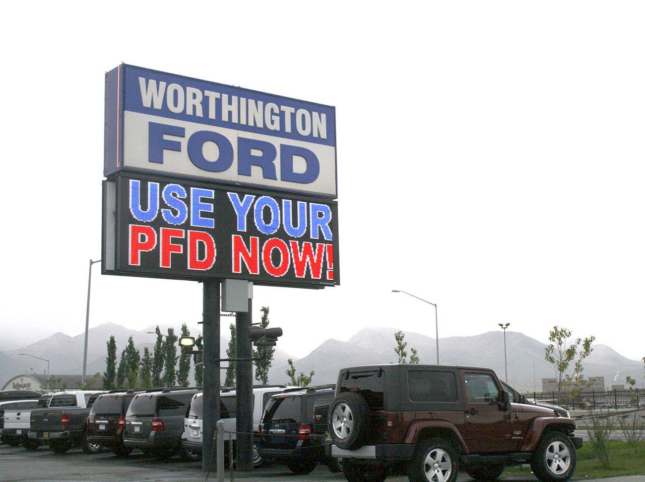 In this 2011 photo, an auto dealership in Anchorage, Alaska, advertises PFD, or Permanent Fund Dividend, sales. An Alaska lawmaker is making one last legal push to put about $1,000 back in the hands of nearly every state resident for their share of Alaska’s oil wealth. (AP Photo/Mark Thiessen, file)