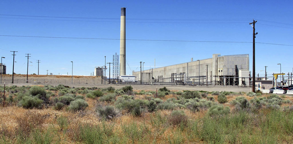 In this June 13 photo, the Plutonium Uranium Extraction Plant (right) stands adjacent to a dirt-covered rail tunnel (left) containing radioactive waste amidst desert plants on the Hanford Nuclear Reservation near Richland. (AP Photo/Nicholas K. Geranios, file)
