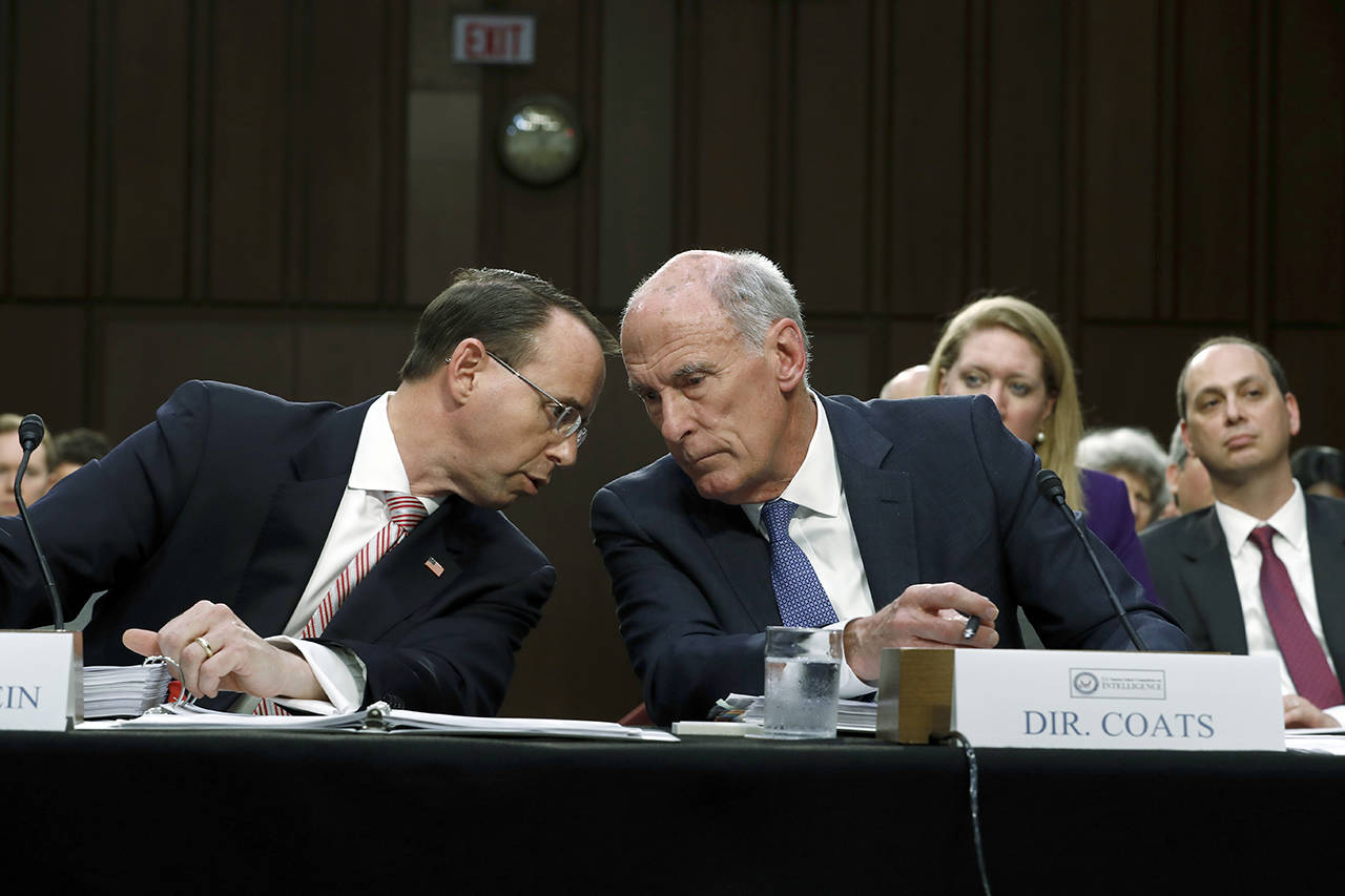 Deputy Attorney General Rod Rosenstein (left) and National Intelligence Director Dan Coats talk on Capitol Hill in Washington on Wednesday, June 7, during the Senate Intelligence Committee hearing on the Foreign Intelligence Surveillance Act. (AP Photo/Carolyn Kaster)