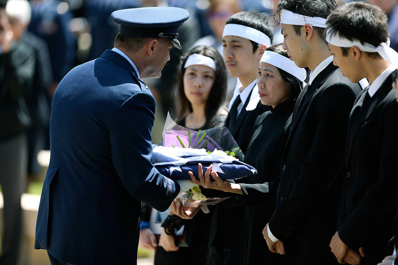 Maj. Gen. Michael E. Stencel presents a United States flag to the family of Ricky Best at Best’s his burial service with military honors Monday at Willamette National Cemetery in Portland, Oregon. Best was one of two men killed May 26 during an attack on a Portland light-rail train. (Dave Killen/The Oregonian via AP)