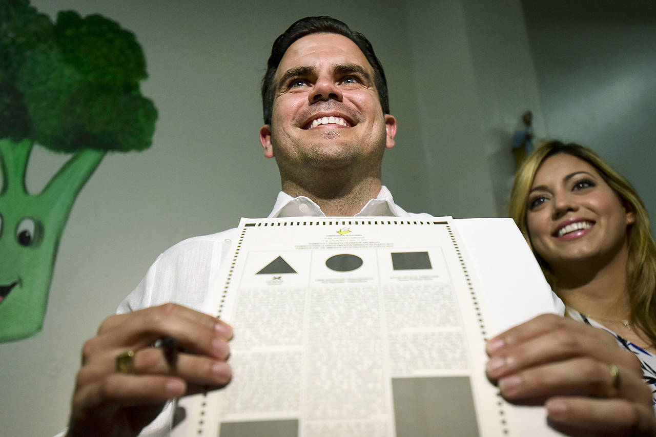 Gov. Ricardo Rossello shows his ballot Sunday at the San Jose Academy during the fifth referendum in San Juan, Puerto Rico. Puerto Ricans are getting the chance to tell U.S. Congress on Sunday which political status they believe best benefits the U.S. territory as it remains mired in a deep economic crisis that has triggered an exodus of islanders to the U.S mainland. Congress ultimately has to approve the outcome of Sunday’s referendum that offers voters three choices: statehood, free association/independence or current territorial status. (AP Photo/Carlos Giusti)