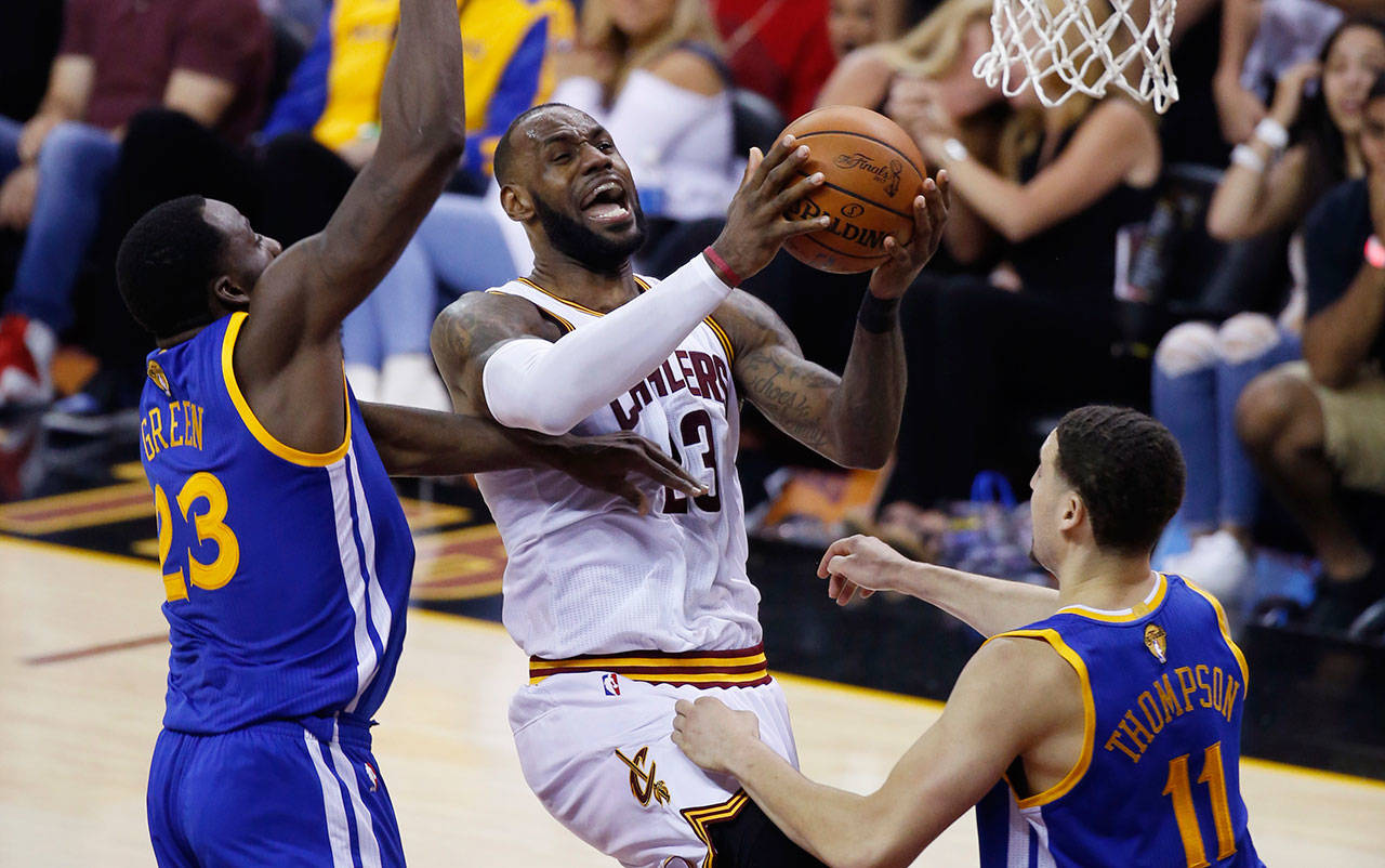 Cavaliers forward LeBron James (23) drives on the Warriors’ Draymond Green (23) and Klay Thompson (11) in the first half of Game 4 of the NBA Finals on June 9, 2017, in Cleveland. (AP Photo/Ron Schwane)