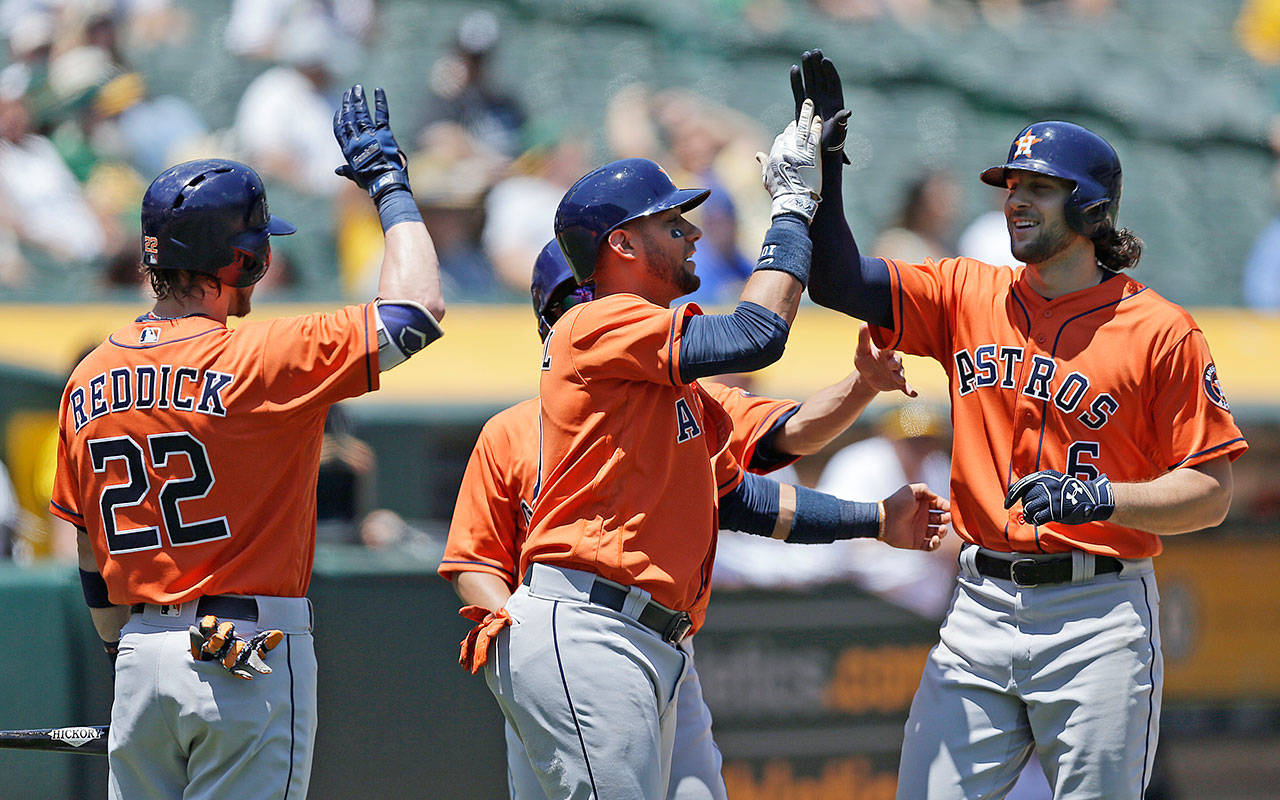 The Astros’ Jake Marisnick (right) is congratulated by Josh Reddick (22) and Yuli Gurriel after hitting a three-run home run against the Athletics in the first inning of a game June 22, 2017, in Oakland, Calif. (AP Photo/Ben Margot)