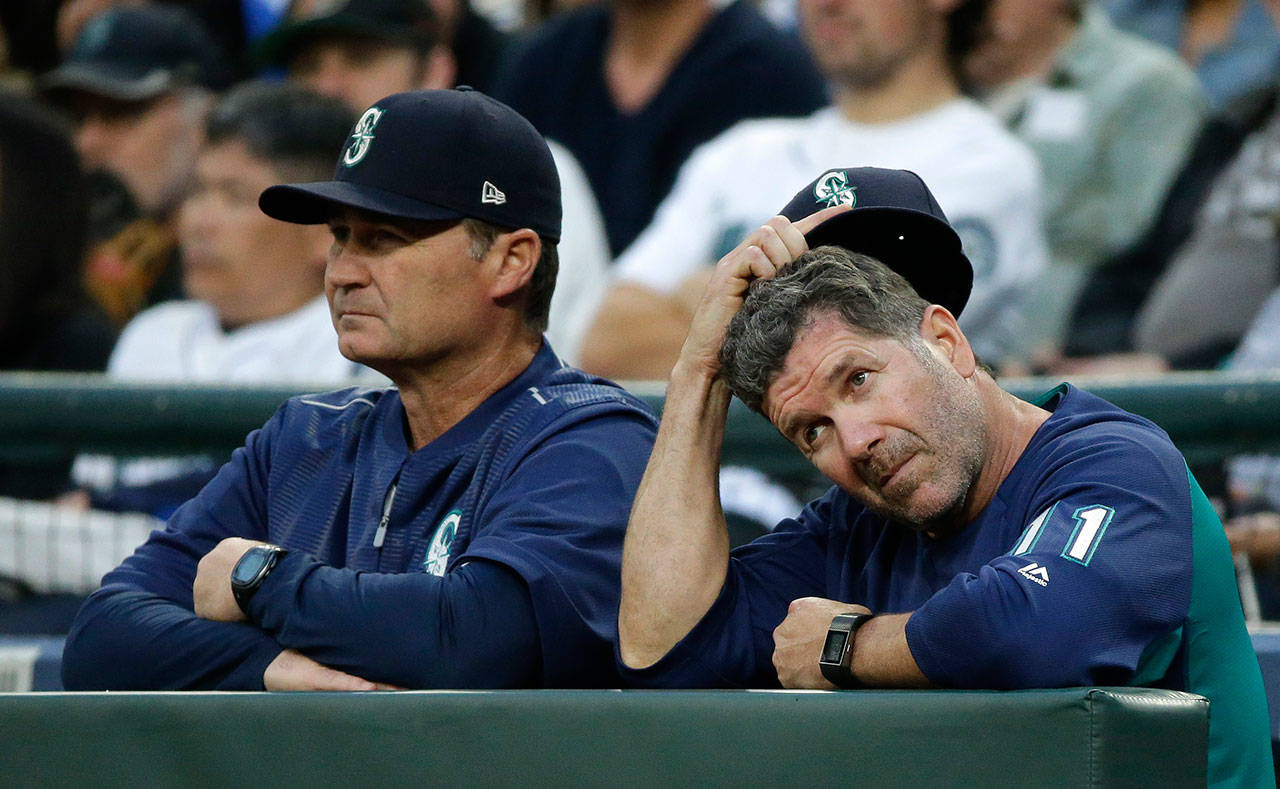 Mariners manager Scott Servais (left) and hitting coach Edgar Martinez watch from the dugout during the fifth inning of a game against the Phillies on June 27, 2017, in Seattle. (AP Photo/Ted S. Warren)
