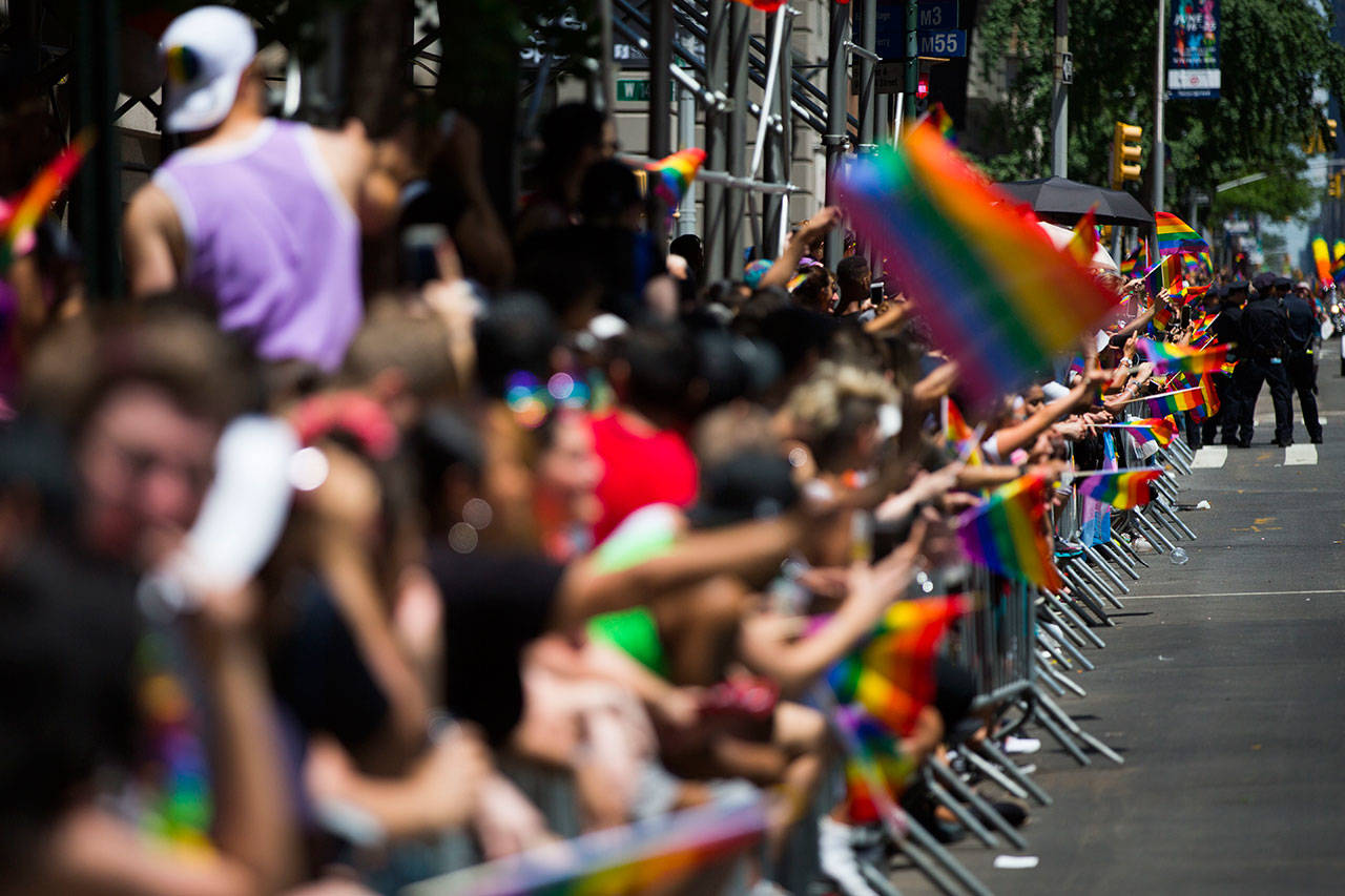 People line the street with rainbow flags as they watch the New York City Pride Parade on Sunday, June 25, 2017 in New York. (AP Photo/Michael Noble Jr.)