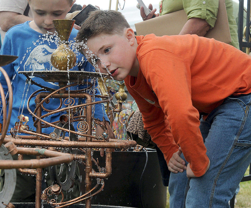 Ethan Stuehrenberg, 8, of Everett, checks out a water garden sculpture by Vancouver B.C. artist Douglas Walker during the 2012 Edmonds Arts Festival at the Frances Anderson Center. (For the Herald/Doug Ramsay)
