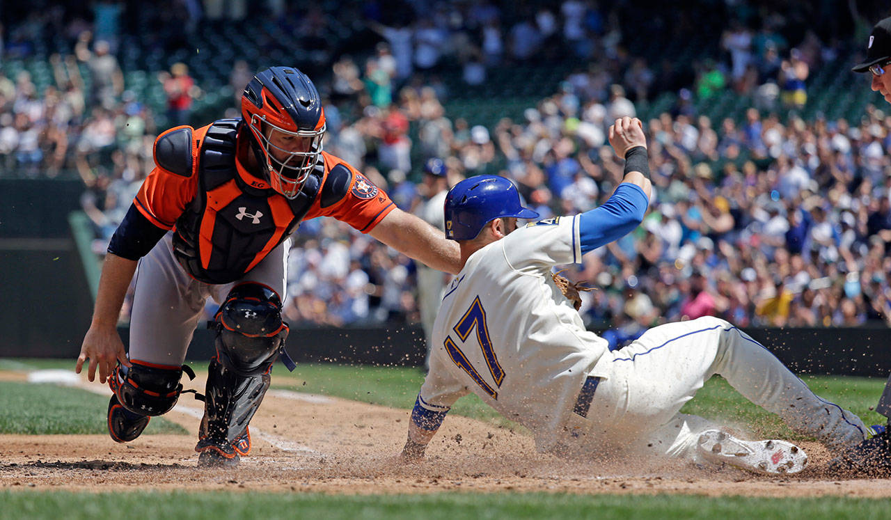 Houston catcher Evan Gattis tags Seattle’s Mitch Haniger at the plate in the second inning of Sunday’s game at Safeco Field. Haniger was called out. (AP Photo / Elaine Thompson)