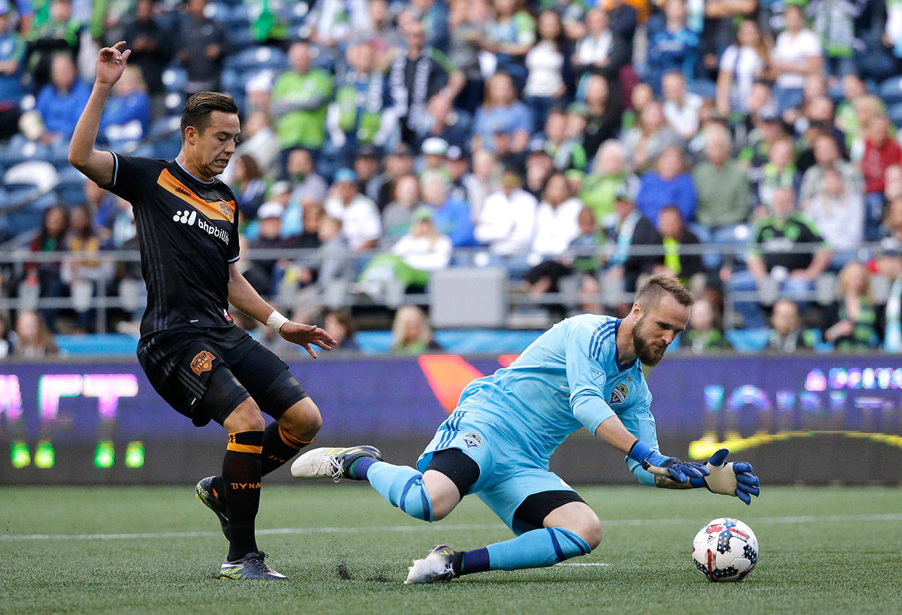 Ted S. Warren / Associated Press                                Seattle Sounders goalkeeper Stefan Frei dives on the ball as Houston Dynamo forward Erick Torres closes in during the first half of an MLS match Sunday in Seattle.