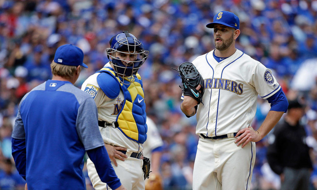 Seattle Mariners starting pitcher James Paxton, right, and catcher Mike Zunino, center, wait to talk with pitching coach Mel Stottlemyre, left, after Paxton gave up the second of two runs to the Toronto Blue Jays in the fourth inning of a baseball game Sunday, June 11, 2017, in Seattle. (AP Photo/Elaine Thompson)
