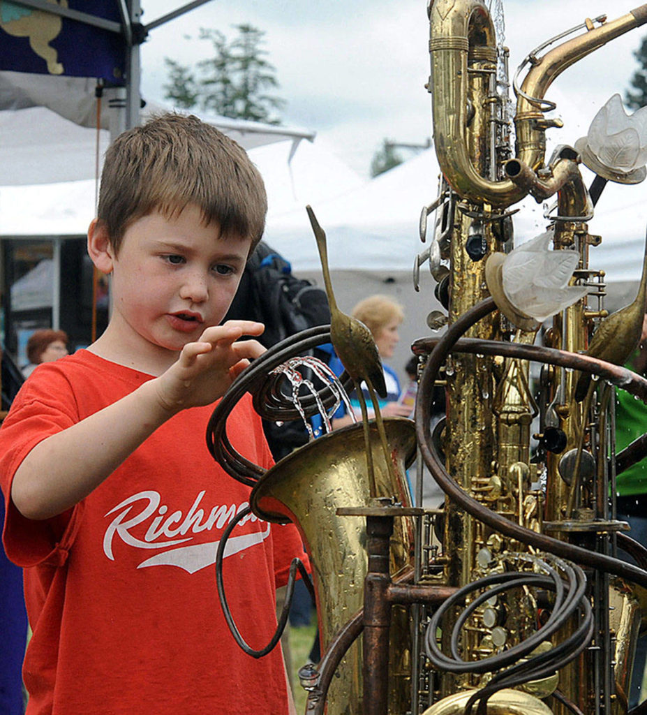 Brody Moen, 7, of Shoreline, checks out a water garden sculpture by Vancouver B.C. artist Douglas Walker during the 2012 Edmonds Arts Festival at the Frances Anderson Center. (For the Herald/Doug Ramsay)
