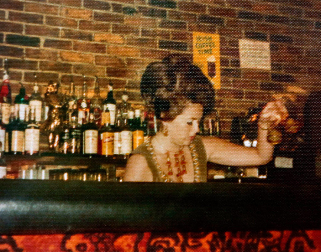 Sue Brauch, now 76, tends bar decades ago at The Flame, at the time a popular Kirkland restaurant overlooking Lake Washington. (Courtesy Sue Brauch)
