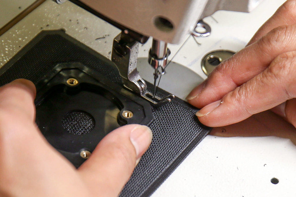 A seamstress sews new helmet padding at RAM Technologies in Mukilteo on June 7. (Kevin Clark / The Herald)
