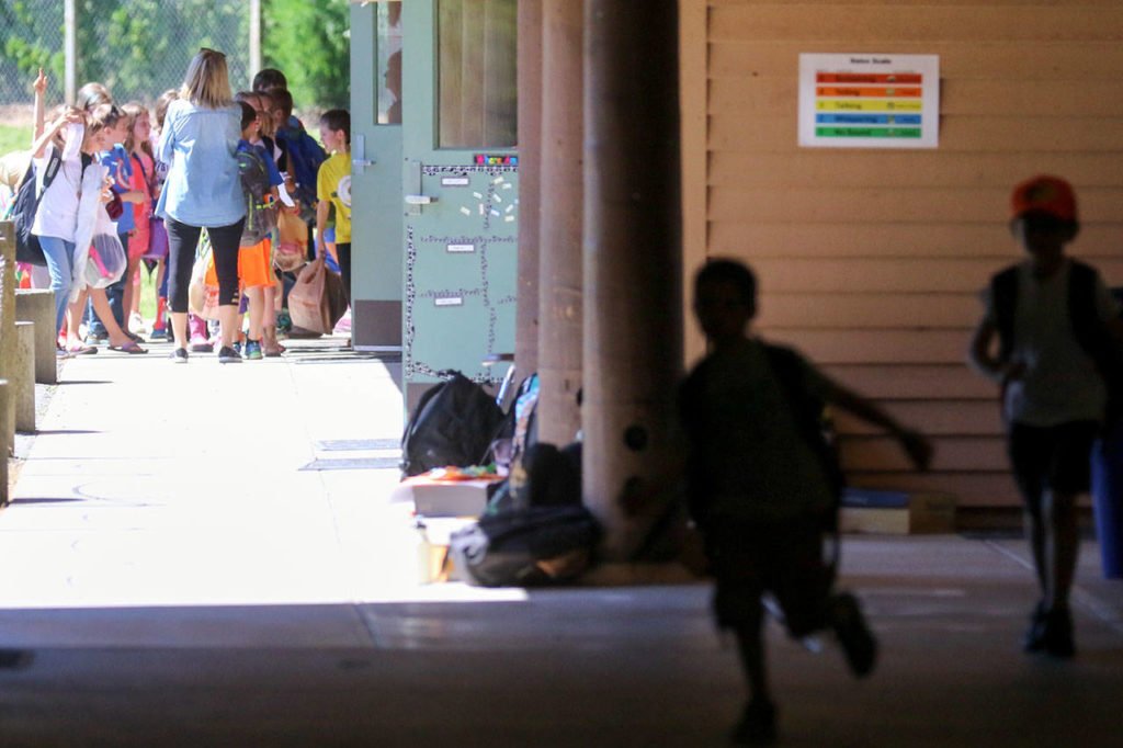 Students leave school for the final full day of classes at Salem Woods Elementary in Monroe on Thursday. (Kevin Clark / The Herald)
