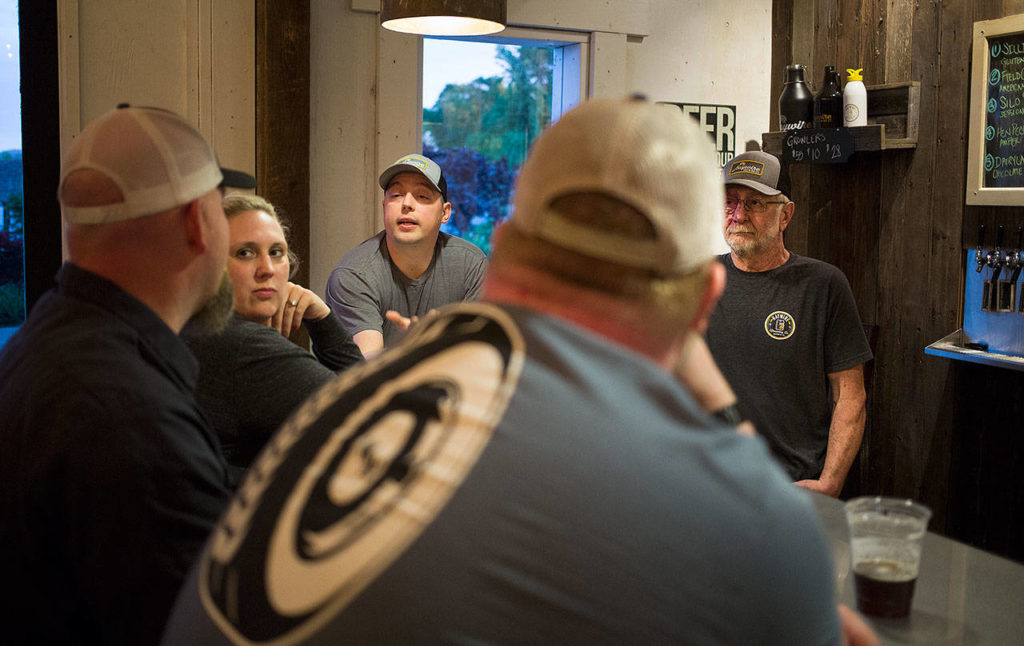 Owner/brewers Bryant Castle (center) and David Jez (right) chat with friends in the main room of Haywire Brewing Co. on May 23 in Snohomish. (Andy Bronson / The Herald)
