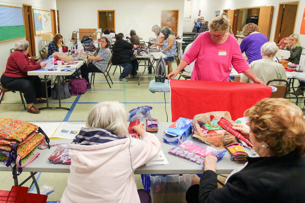 Volunteers assemble bags of hygiene products for distribution to women around the world Saturday morning at Bethel Baptist Church in Everett on June 17, 2017. (Kevin Clark / The Herald)
