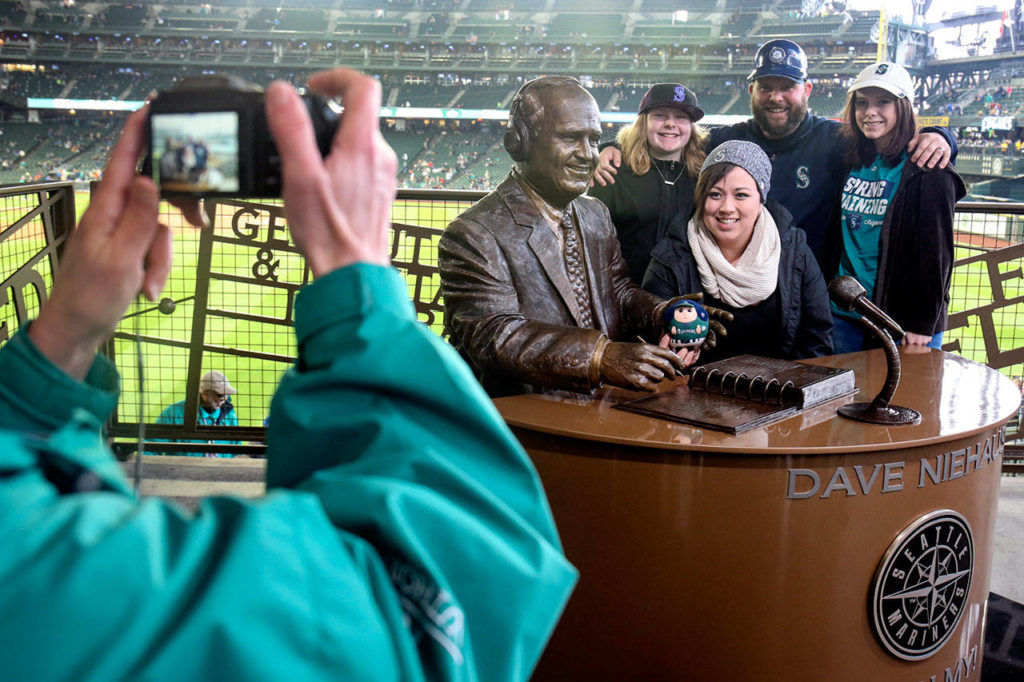 Mystery Merwine (from left), Keira Merwine, Matt Merwine and Madison Merwine pose for a photo with the statue of Mariners sportscaster Dave Niehaus at Safeco Field. (Kevin Clark / The Herald)
