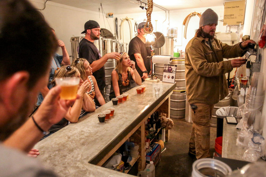 Greg Krsak (far right), owner and operator of Scrappy Punk Brewery, pours samples. (Kevin Clark / The Herald)
