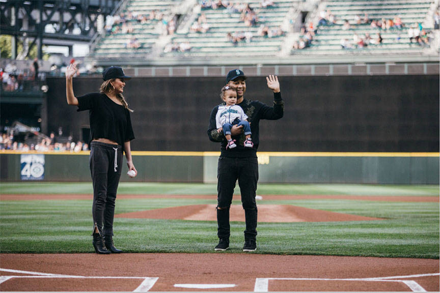 Former Snohomish resident turned supermodel Chrissy Teigen and her musician husband John Legend, holding their baby Luna, threw out the first ceremonial pitch at Tuesday’s Seattle Mariners game. (Ben VanHouten / Seattle Mariners)
