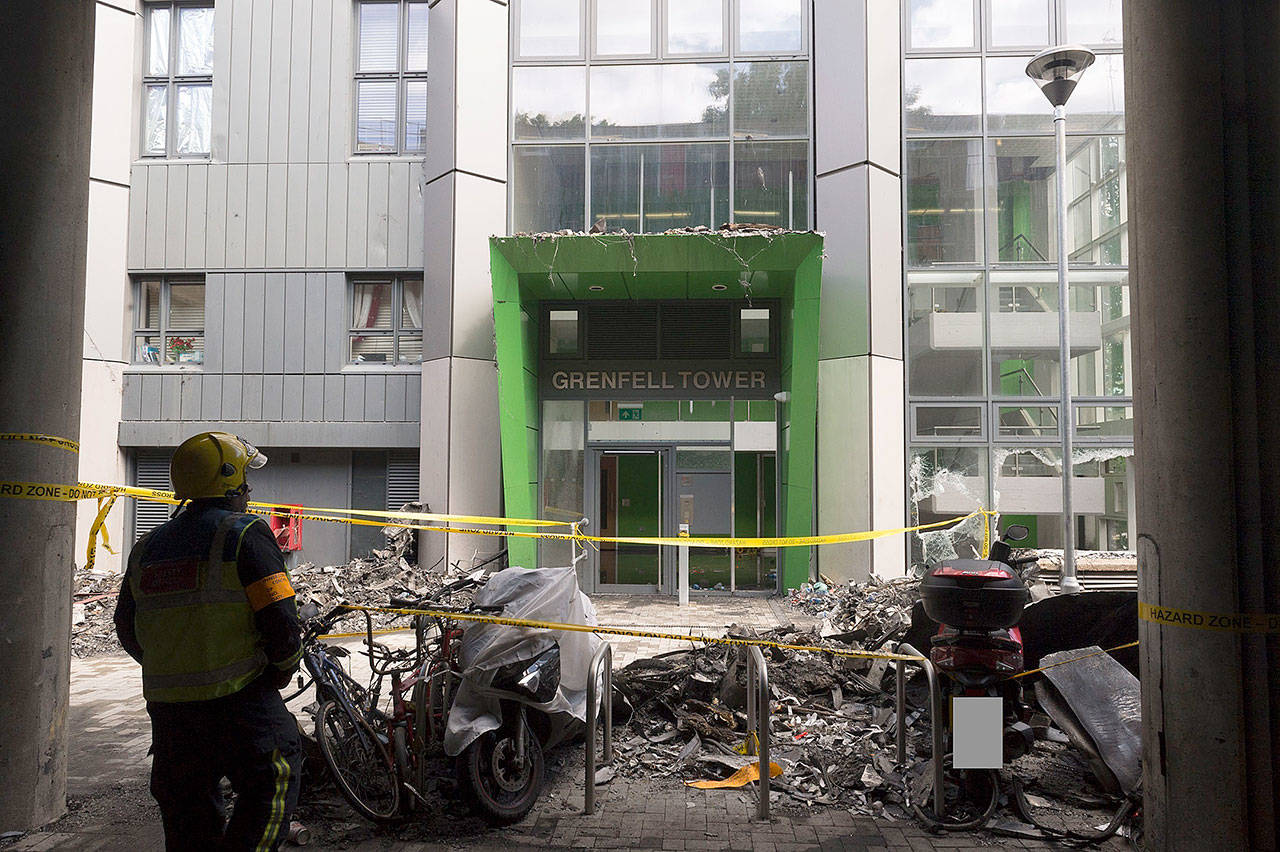 In this photo released by the Metropolitan Police on Sunday, a firefighter stands outside of the Grenfell Tower after fire engulfed the 24-storey building, in London. (Metropolitan Police via AP)