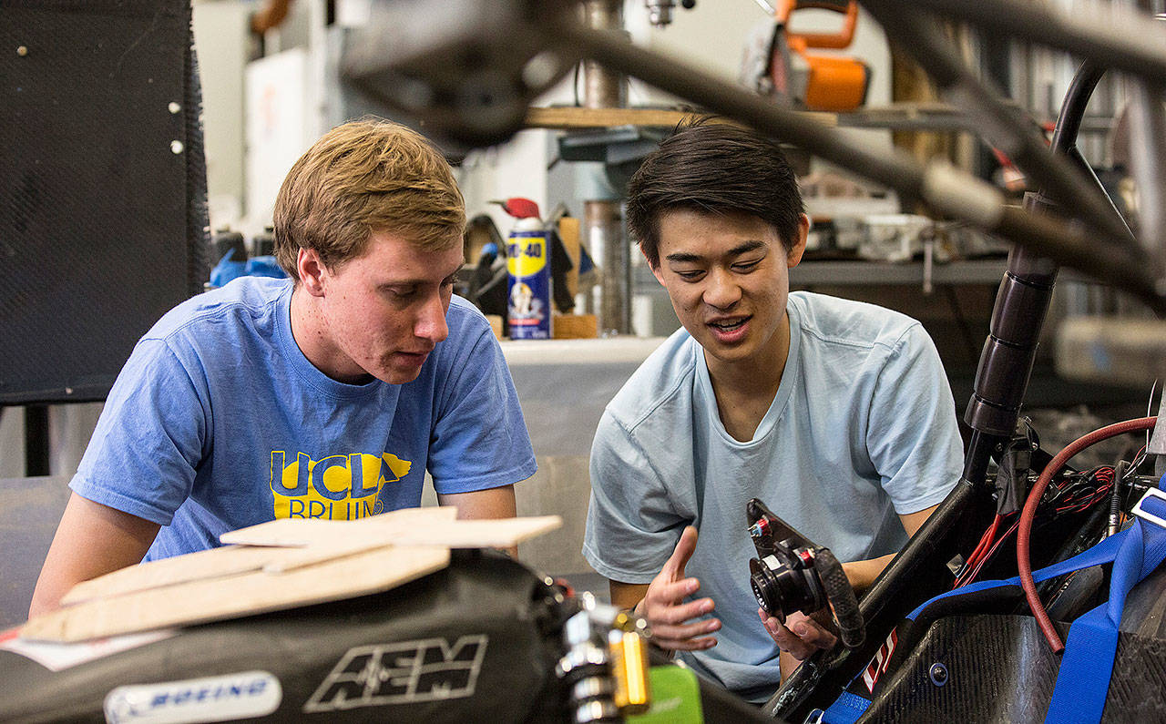 UCLA students Brent Kyono (right) and Luke Allee compare parts for UCLA Formula SAE team car in the Westwood campus workshop in Los Angeles, California, on May 3. (Brian van der Brug/Los Angeles Times)
