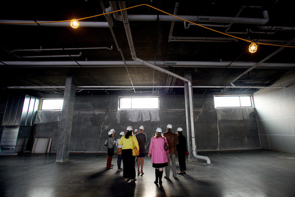 People get a sneak peek at an area that was to be a farmers market, at Potala Place, 2900 Grand Ave. in Everett, in April 2015. (Ian Terry / The Herald)
